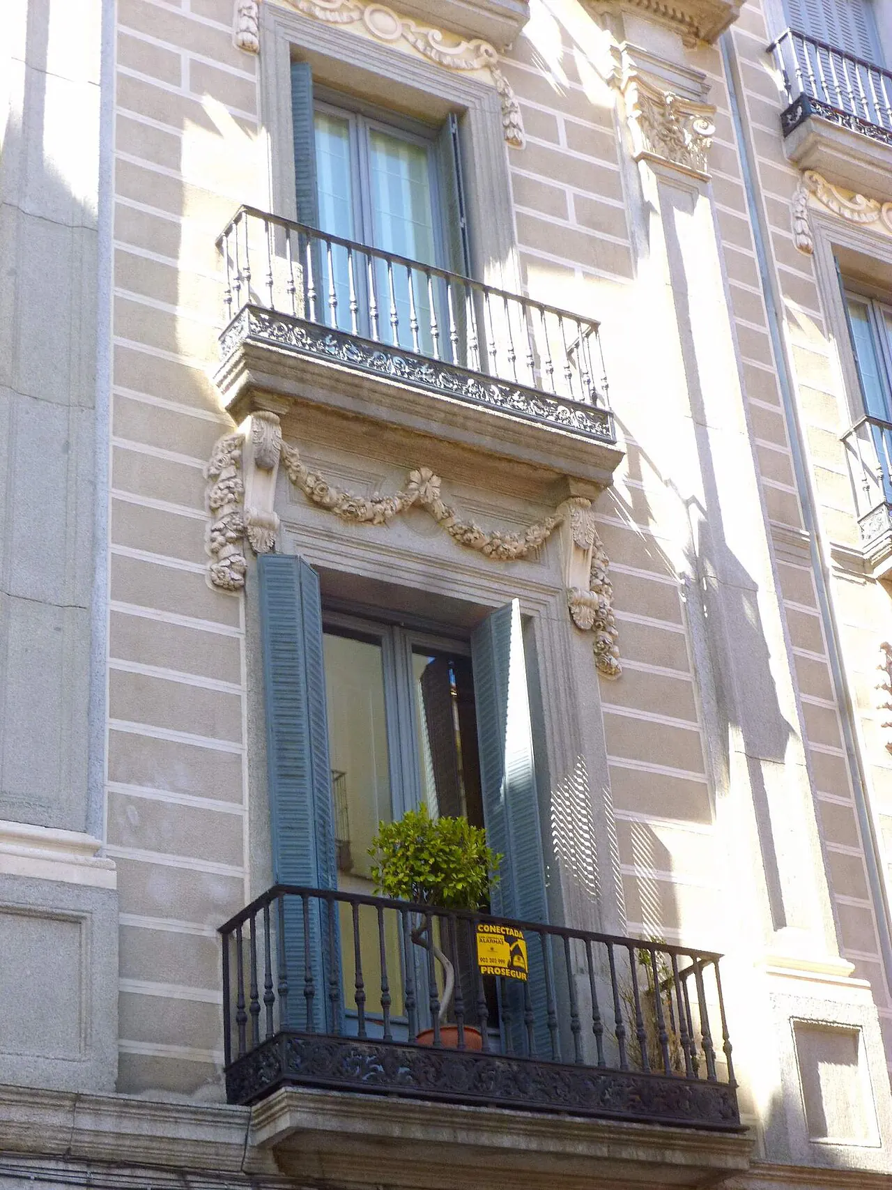 Un edificio pintado de Madrid con balcones y plantas